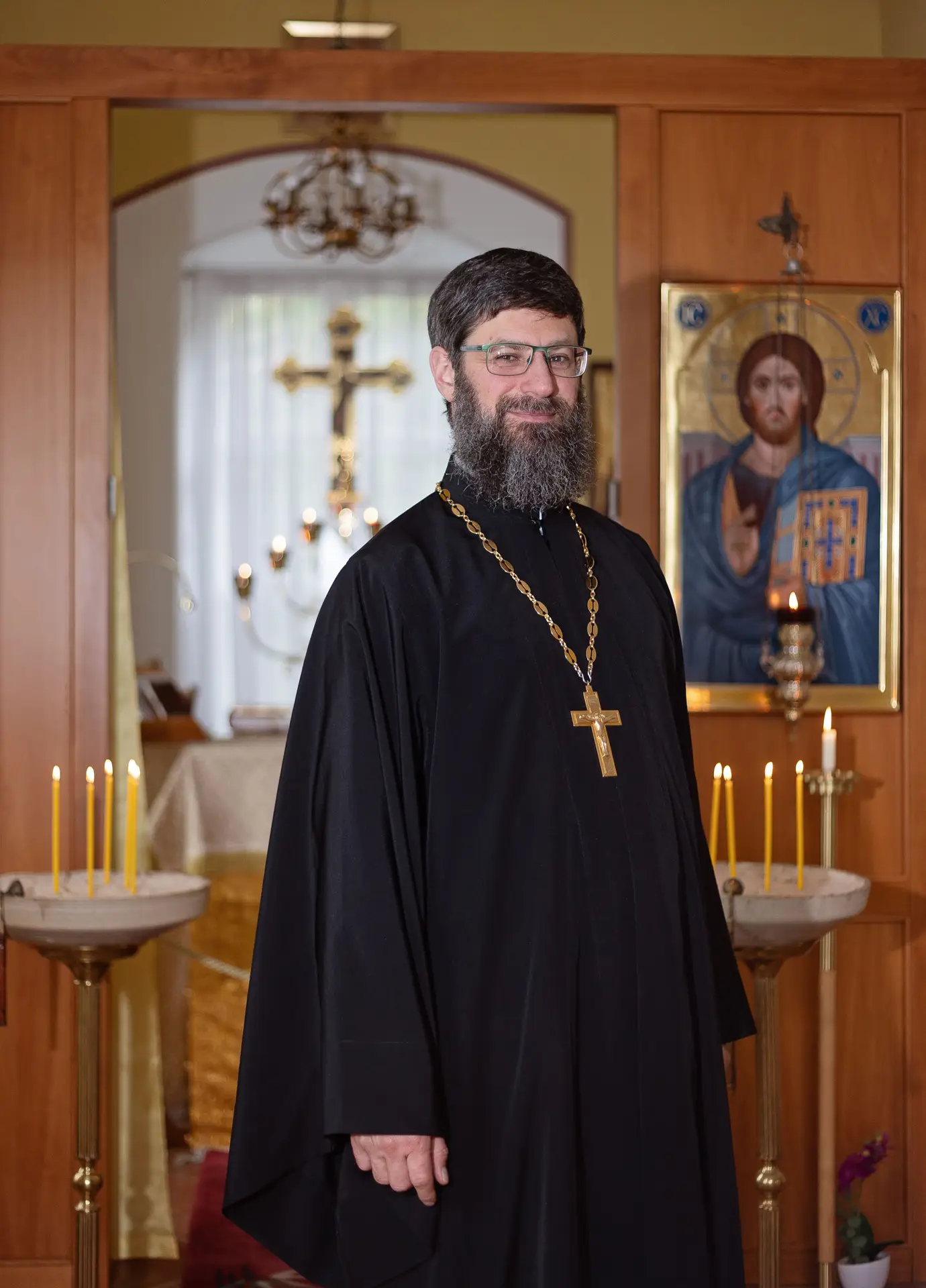 Vater Vladimir Bayanov in schwarzem Priestergewand mit Brustkreuz vor einer Christus-Ikone im Zeller Torhaus