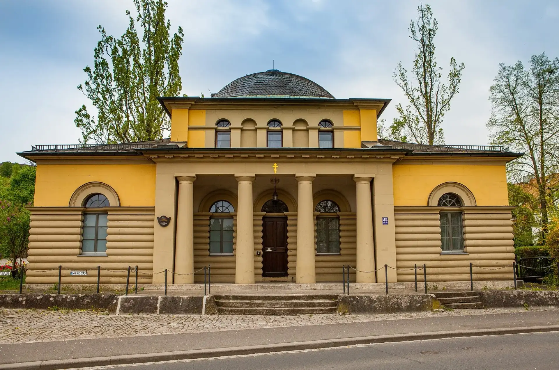 Das Zeller Torhaus von vorn: gelber klassizistischer Bau mit Säulen und Kuppel, über dem Eingang ein goldenes Kreuz
